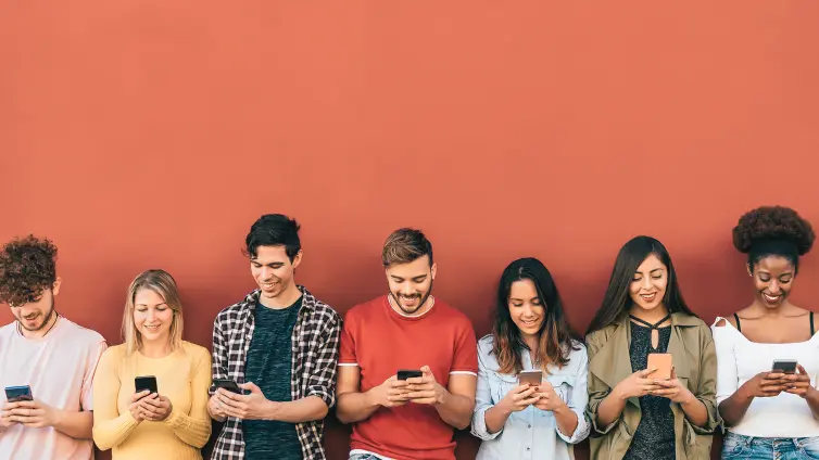 Group of people in a row looking at smartphones.