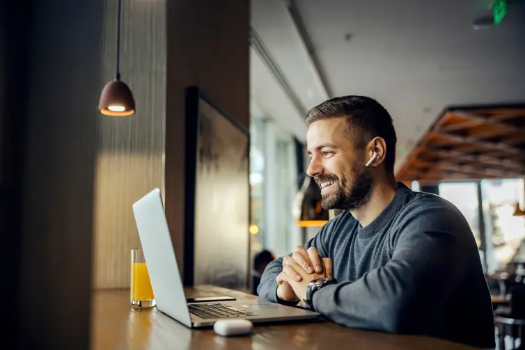 Man smiling using a laptop.