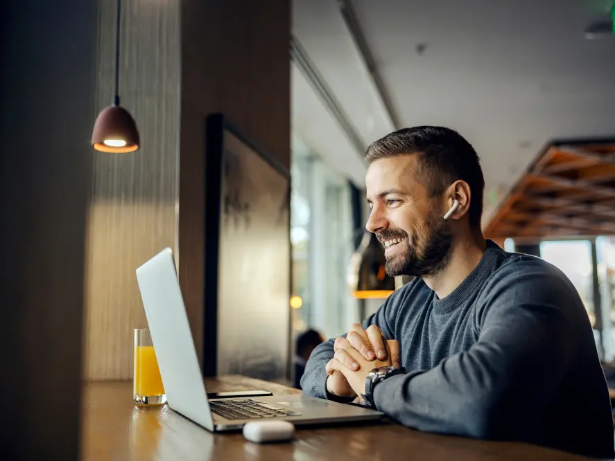 Man smiling using a laptop.