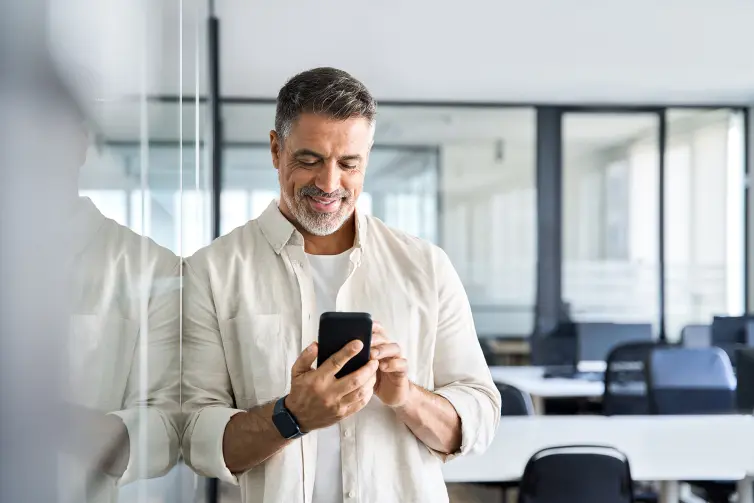 Middle aged manager using cell phone mobile app.