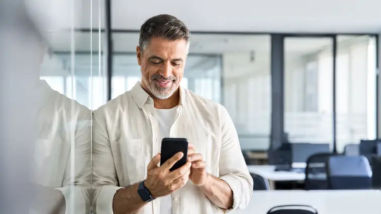 Middle aged manager using cell phone mobile app.